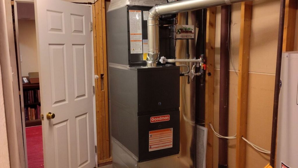 a furnace and water heater in an unfinished basement