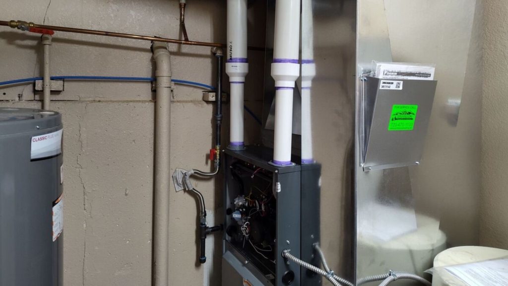 a gas furnace and pipes in a room