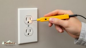 A person is using an electrical outlet to plug in an outlet