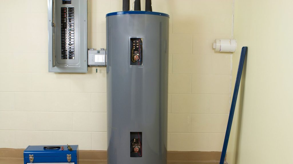 a large traditional water heater sitting next to a tool box