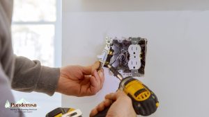 a person is using a drill to install an electrical outlet